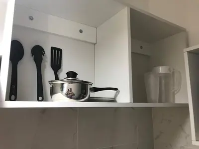 a kitchen shelf with a pot and utensils on it at Albano habitación acústica cocina y baño in Chosica
