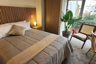 a bedroom with a bed and a chair and a plant at Amazing 3BR in Miraflores in Lima