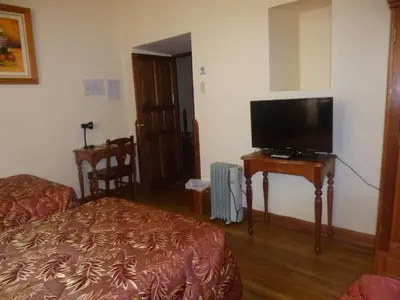 a hotel room with a bed and a flat screen tv at Hotel Midori in Cusco