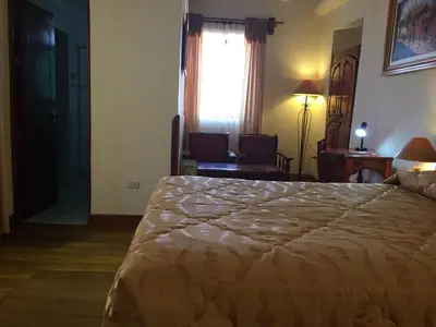 a bedroom with a large bed and a window at Hotel Midori in Cusco