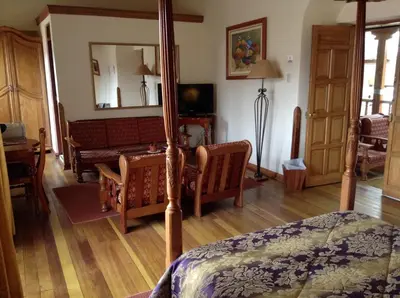 a bedroom with a bed and a living room at Hotel Midori in Cusco