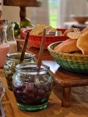 a table topped with jars of food and baskets of bread at Sierra Sacred Valley in Urubamba