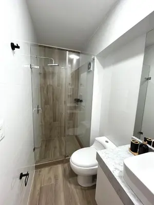 a white bathroom with a shower and a toilet at Departamento de Estreno en Miraflores in Lima