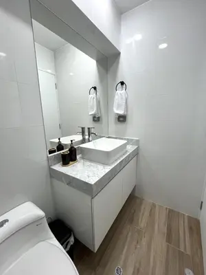a white bathroom with a sink and a toilet at Departamento de Estreno en Miraflores in Lima