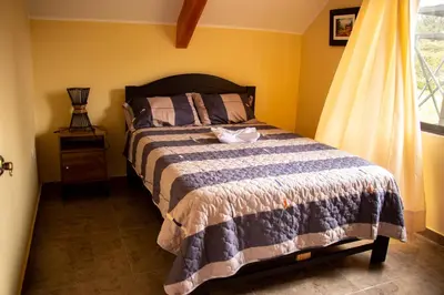 a bedroom with a bed and a window at La casa de Anni - Departamento 1 in Oxapampa