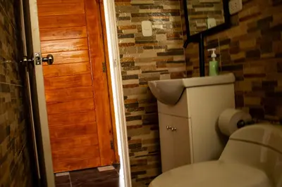 a bathroom with a toilet and a wooden door at La casa de Anni - Departamento 1 in Oxapampa