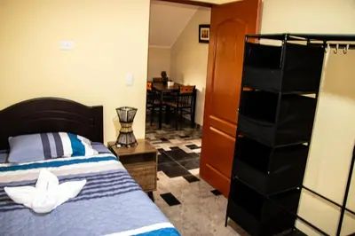 a bedroom with a bed and a dresser at La casa de Anni - Departamento 1 in Oxapampa