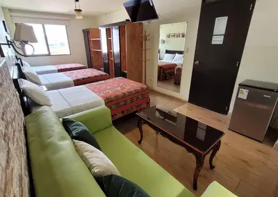 a hotel room with two beds and a couch at Hotel Tinkus Inn in Lima