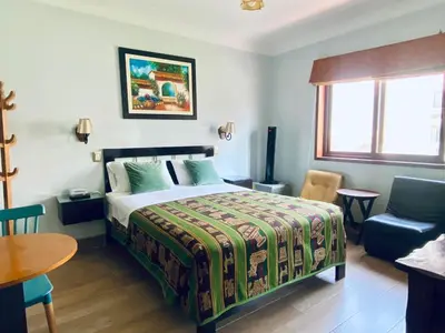 a bedroom with a bed and a table and a chair at Hotel Tinkus Inn in Lima