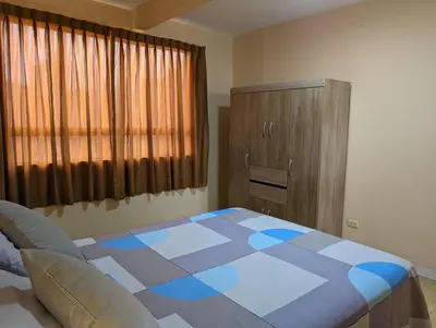 a bedroom with a bed and a wooden cabinet at Apartamento privado, comodo y amplio, cerca al Centro de Lima in Lima