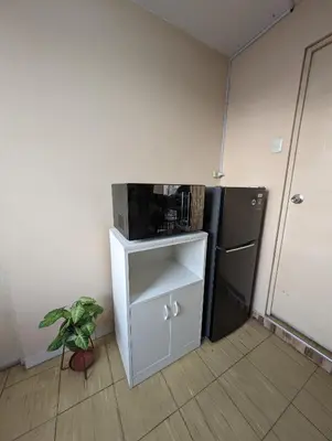 a small kitchen with a microwave and a refrigerator at Apartamento privado, comodo y amplio, cerca al Centro de Lima in Lima