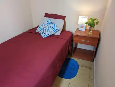 a small bedroom with a bed and a night stand at Apartamento privado, comodo y amplio, cerca al Centro de Lima in Lima