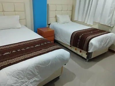 two beds sitting next to each other in a room at hotel plaza chinchero in Cusco