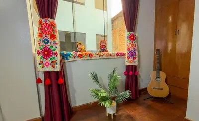 a room with a counter with a guitar and curtains at Apart Hotel de Alegria in Cusco