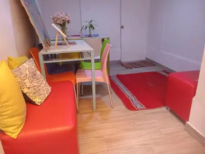 a living room with a red couch and a table at Colores Hospedaje Miraflores in Lima