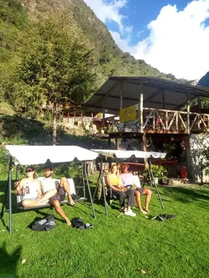 a group of people sitting under umbrellas in the grass at HOSTEL SAMANA WASI CHAULLAY in Cusco