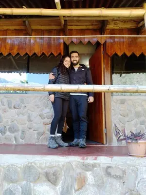 a man and a woman standing in front of a building at HOSTEL SAMANA WASI CHAULLAY in Cusco