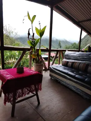 a room with a bench and a table with a plant at HOSTEL SAMANA WASI CHAULLAY in Cusco