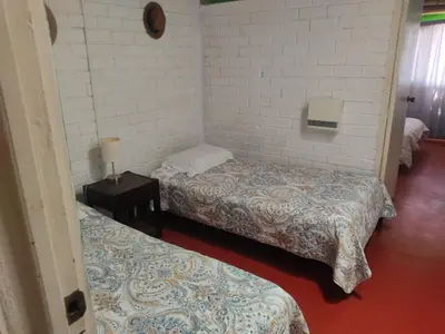 a room with two beds and a night stand with two beds at Beach House SantaElena in Pisco