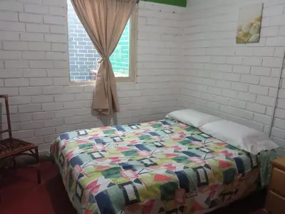 a bedroom with a bed with a quilt on it at Beach House SantaElena in Pisco