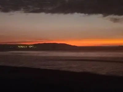 a sunset over a body of water with at Beach House SantaElena in Pisco