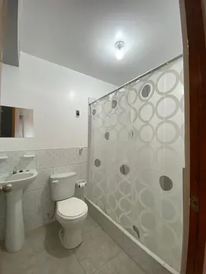 a bathroom with a toilet and a glass shower at Casa Hospedaje El Trebol in Oxapampa