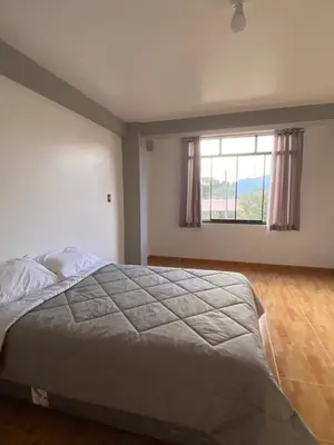 a bedroom with a large bed and a window at Casa Hospedaje El Trebol in Oxapampa