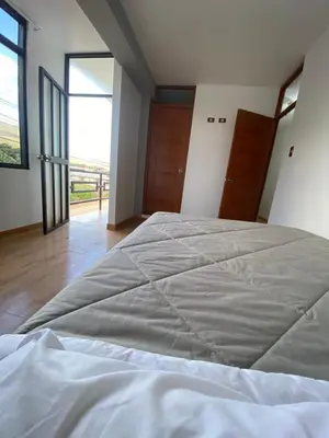 a large bed in a room with a large window at Casa Hospedaje El Trebol in Oxapampa
