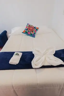 a white bed with two pillows on top of it at BEAUTIFUL, SPACIOUS & COZY HOUSE LOCATED IN THE HEART OF CUSCO in Cusco