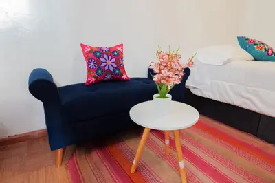 a living room with a blue chair and a table at BEAUTIFUL, SPACIOUS & COZY HOUSE LOCATED IN THE HEART OF CUSCO in Cusco
