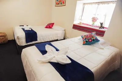 a room with two beds and a window at BEAUTIFUL, SPACIOUS & COZY HOUSE LOCATED IN THE HEART OF CUSCO in Cusco