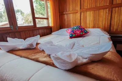 a large bed with a pillow on top of it at BEAUTIFUL, SPACIOUS & COZY HOUSE LOCATED IN THE HEART OF CUSCO in Cusco