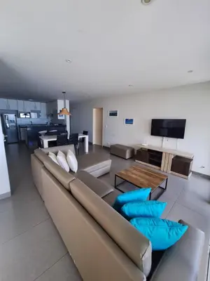 a living room with a couch and a table at Nuevo Paracas Apartment in Paracas