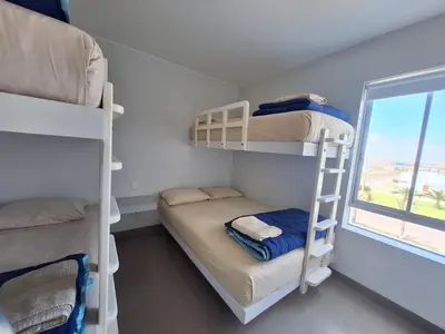 a small room with bunk beds and a window at Nuevo Paracas Apartment in Paracas
