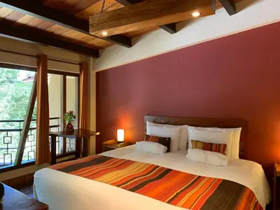 a bedroom with a large bed with a red wall at Panorama B&B in Machu Picchu
