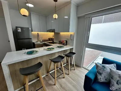 a kitchen with a counter and stools in a room at Cozy Apartment in Barranco! in Lima
