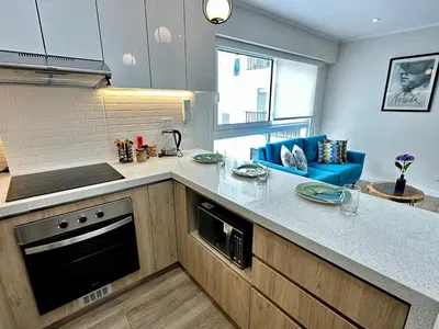 a kitchen with a counter and a blue couch at Cozy Apartment in Barranco! in Lima