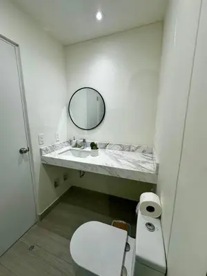 a bathroom with a sink and a mirror and a toilet at Cozy Apartment in Barranco! in Lima