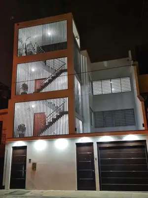 a building with two garage doors and a balcony at Dormitorio matrimonial 02 in Lima