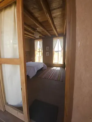 a view of a bedroom with a bed and windows at Pampachayoq - Mountain retreat in Urubamba