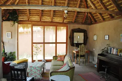 a living room with a couch and a piano at Pampachayoq - Mountain retreat in Urubamba