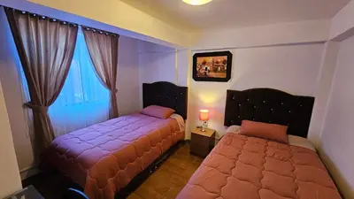 a bedroom with two beds and a window at Casa Independiente cerca al centro historico en Primer Piso - Los Profesionales in Cusco