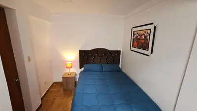 a bedroom with a blue bed in a room at Casa Independiente cerca al centro historico en Primer Piso - Los Profesionales in Cusco