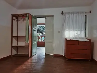 an empty room with a dresser and a window at Casa Verde in Quillabamba