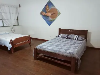 a bedroom with a bed and a small bed sidx sidx sidx at Casa Verde in Quillabamba