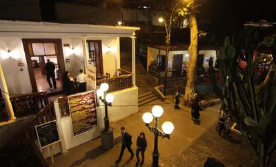 a group of people walking down a street at night at Casita Libertad Barranco in Lima