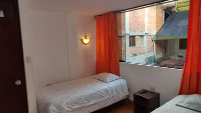 a small bedroom with a bed and a window at Tierra Mágica Hostal in Machu Picchu
