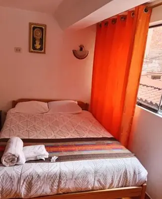 a small bedroom with a bed and a window at Tierra Mágica Hostal in Machu Picchu