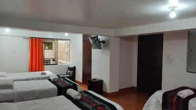 a hotel room with two beds and a window at Tierra Mágica Hostal in Machu Picchu