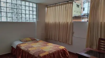 a small bedroom with a bed and a window at Tierra Mágica Hostal in Machu Picchu